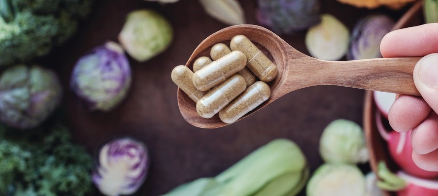 Keski�ss� ravintolis�kapseleita puulusikassa, alapuolella p�yd�ll� kaalinkeri�.